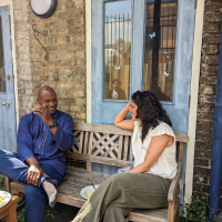 two people of colour sat outside chatting